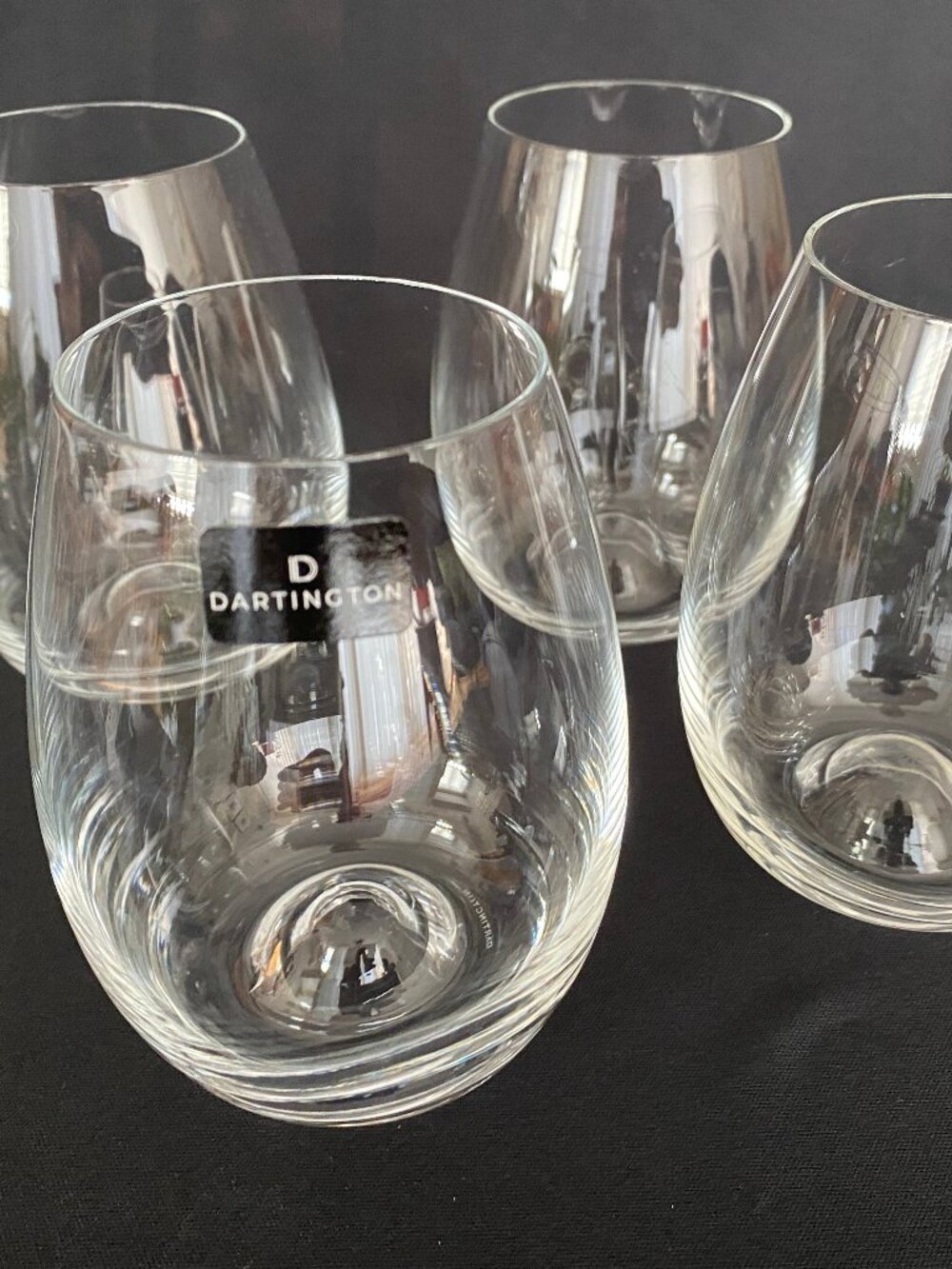 Set of four (4) Dartington crystal stemless wine glasses.